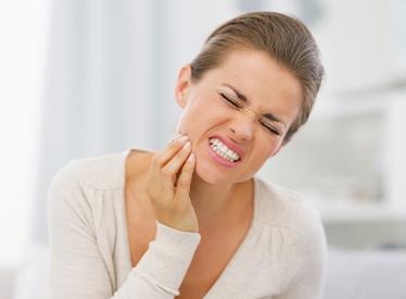 woman gritting teeth in pain
